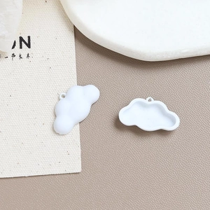 Detailed macro view of white cloud-shaped alloy charms with top loops for DIY jewelry making