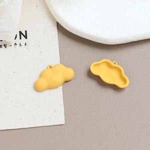 Detail view of yellow cloud-shaped alloy charms with front and back structure for DIY crafts