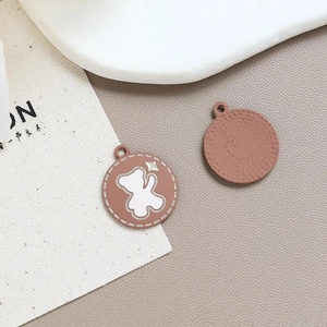 Macro shot of pink enamel bear pendants with decorative stars for DIY jewelry