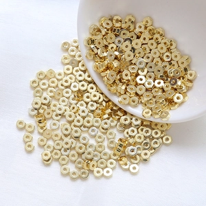 Close-up of bulk 14k gold plated hexagonal spacer beads for jewelry DIY on white background