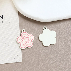 Close-up of pink flower enamel alloy charms with polished finish for DIY jewelry crafts