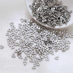 Close-up of heart-shaped silver spacer beads for DIY jewelry making on white background