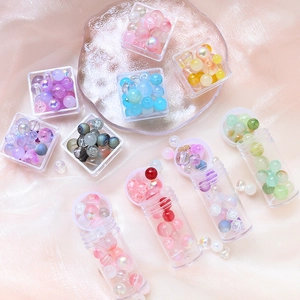 Close-up of assorted colorful glass beads in clear boxes for DIY jewelry making
