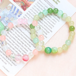 Pink and green DIY beaded bracelet sets with iridescent and crackle glass beads on a card
