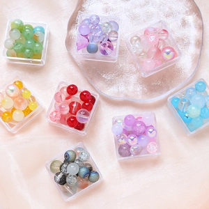 Close-up of colorful DIY bead sets in plastic boxes on a pink silk background fabric
