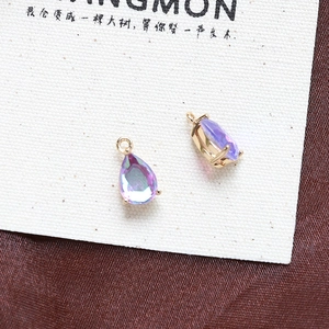 Macro shot of purple teardrop crystal charms with gold frame for DIY jewelry making