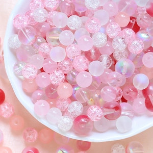 Detailed view of pink DIY glass beads with frosted and crackle textures for jewelry