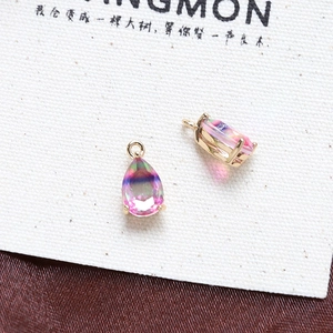 Macro shot of two pear-shaped rainbow zircon pendants with gold plated four-claw settings