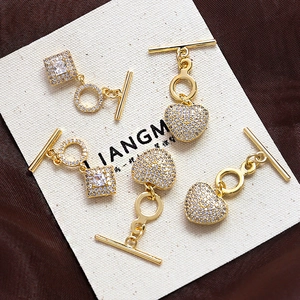 Macro view of gold-plated heart and square OT toggle clasps with shimmering cubic zirconia