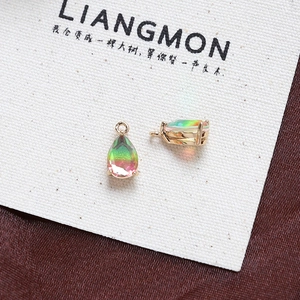 Macro shot of two teardrop pendants with gradient green-to-pink crystal and gold plating