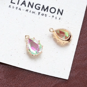 Macro shot of two colorful teardrop crystal pendants with golden edges for jewelry making