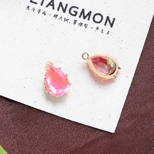 Macro detail of pear-shaped pink crystal pendants with gold-plated prong settings for DIY jewelry