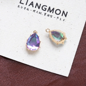 Detailed macro view of pear-shaped iridescent zircon charms with gold plated bases for jewelry DIY