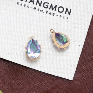 Macro shot of two teardrop-shaped Aurora Borealis crystals set in gold-plated claw frames