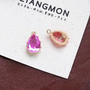 Close-up of teardrop zircon pendants with gold-plated claw settings for DIY jewelry