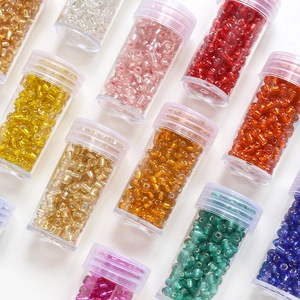 Multi-color 4mm glass seed beads with gold foil inside organized in clear plastic vials