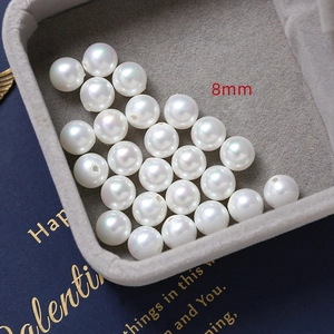Close-up of 8mm white round pearls with high gloss and center holes for DIY jewelry