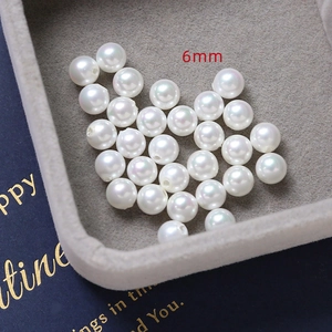 Macro shot of 6mm white iridescent DIY pearl beads scattered in a jewelry box