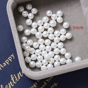 Detailed macro view of 5mm high-gloss white DIY jewelry pearls on velvet tray