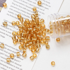 Macro shot of 4mm amber glass seed beads with silver lining for DIY jewelry making