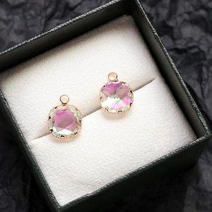 Détail macro de pendentifs carrés en zircone avec bords dorés dans un coffret à bijoux