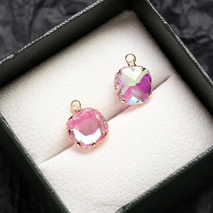 Gros plan de pendentifs en zircon rose dégradé avec bordure dorée dans un écrin noir