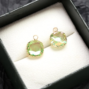 Gros plan de pendentifs verts facettés avec monture dorée pour création de bijoux DIY