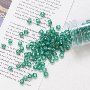 Macro shot of 4mm emerald glass seed beads with silver lining for DIY jewelry making