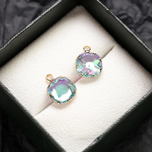 Vue macro de pendentifs dorés sertis de cristaux irisés facettés pour bijoux DIY