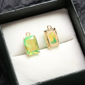 Vue détaillée de pendentifs rectangulaires en cristal dégradé jaune-vert sertis d'or