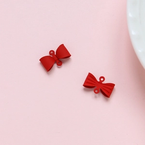 Detail van rode matte strikbedeltjes met gladde en getextureerde afwerkingen voor sieraden