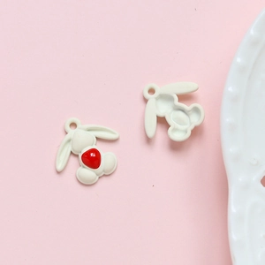 Detail van schattige witte konijnenhangers met rood hart voor DIY sieraden maken