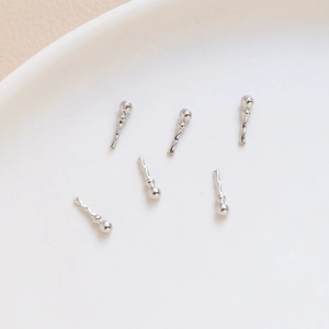 Macro shot of 6 silver twisted metal pins with bead heads for DIY jewelry making