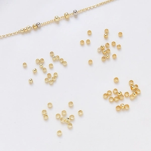Perles d'espacement plaquées or pour bijoux DIY sur un fond blanc minimaliste élégant