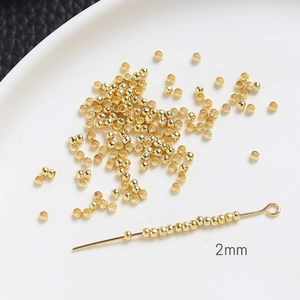 Vue macro de perles de positionnement dorées de 2mm pour la création de bijoux DIY