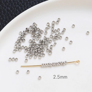 Détail macro de perles à écraser argent de 2,5mm sur tige dorée pour bijoux DIY