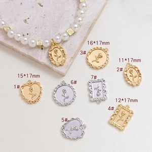 Detail of rose embossed vintage pendants with sizes and pearl necklace on stone plate
