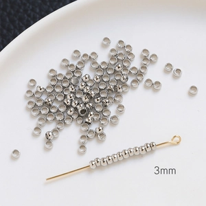 Détail macro de perles d'espacement en métal argenté de 3 mm pour bijoux et colliers