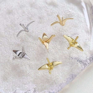Vue macro de breloques grue en origami plaquées or 14K et argent pour bijoux DIY