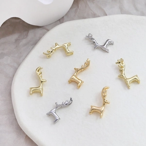 Vista dettagliata di ciondoli a forma di cervo in oro e argento per gioielli DIY