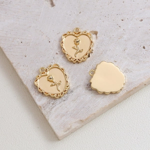 Macro shot of gold-plated heart pendant with vintage rose relief for DIY jewelry making