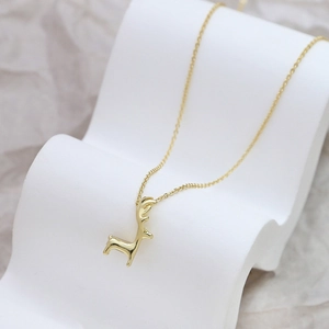 Collana con ciondolo a forma di cervo placcata oro su un elegante supporto a onde bianche