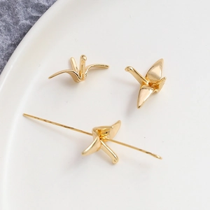 Détail macro de pendentifs grue origami plaqués or 14K avec trou pour bijoux DIY