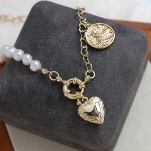 Macro detail of gold-plated French photo frame pendant and Little Prince coin on necklace