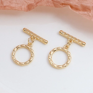 Détail de fermoirs à bascule dorés avec texture martelée pour bijoux DIY