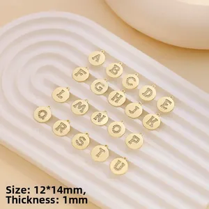 Detailed view of gold-plated round letter pendants with clear cubic zirconia stones