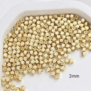 Macro detail of 3mm gold-plated faceted copper beads for DIY jewelry making accessories