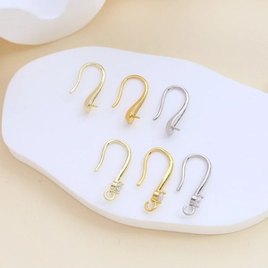Detalle de ganchos de cobre bañados en oro con circonitas y bucles para joyería artesanal