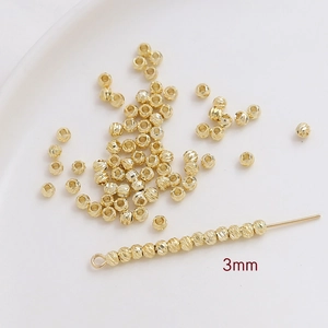 Vista macro de cuentas espaciadoras de 3mm bañadas en oro con grano vertical para joyas DIY
