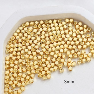 Macro detail of 3mm gold-plated faceted square beads for DIY jewelry making